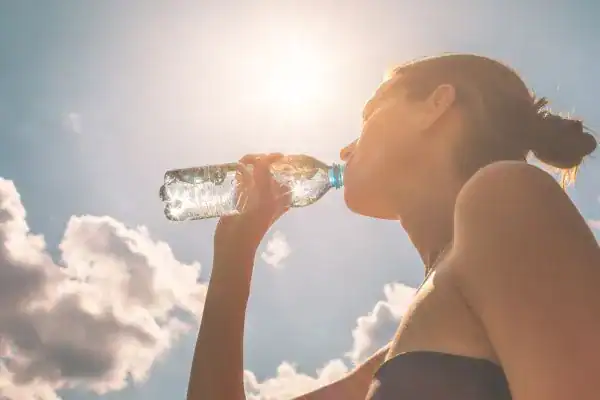 Hydration: The Secret Ingredient for a Toned Stomach and Enhanced Fitness 3 Image of woman drinking water to hydrate Midlands after run.